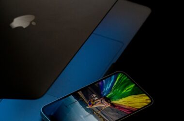 phone on a dark laptop, phone screen blazing with saturated colour