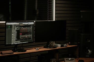 Wide dark suite: slat acoustic wall, ADAM monitors, console desk