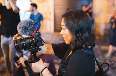 Creator shooting handheld Canon rig with Rode on-camera mic on location