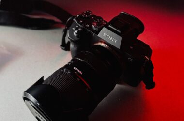 A professional mirrorless camera lit with dramatic red light