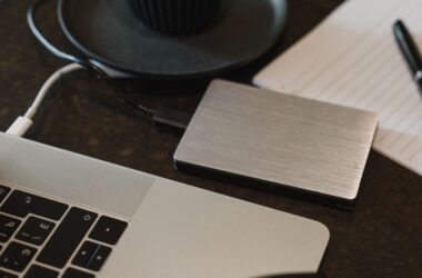 External hard drive connected to a laptop with a USB cable on a dark desk