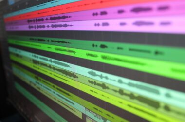 Angled close-up of coloured multitrack dialogue waveforms in a DAW