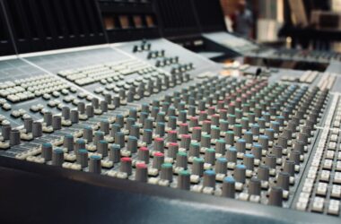 Audio mixing console faders in a dark studio