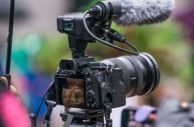 A Sony mirrorless camera on a tripod with an XLR audio adapter and shotgun microphone mounted on top
