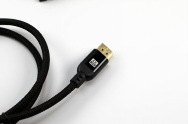 A braided HDMI cable with a gold connector on a white surface
