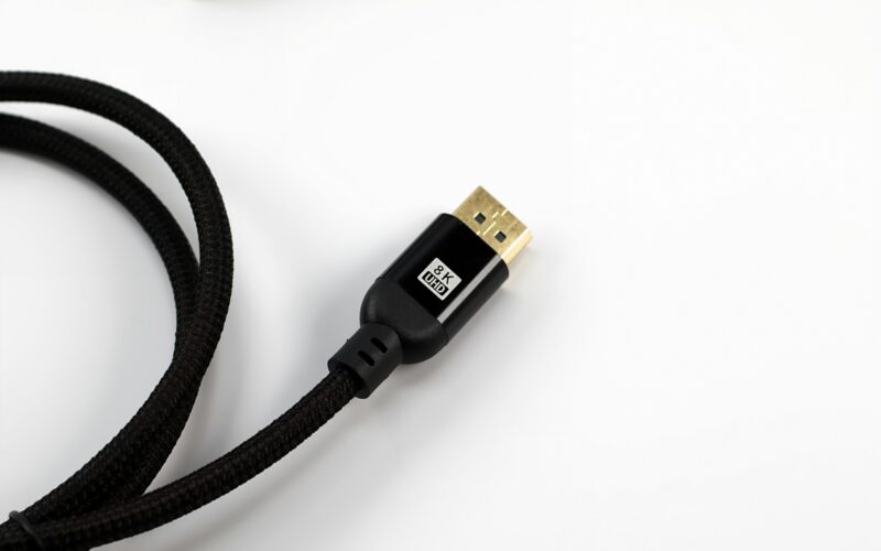 A braided HDMI cable with a gold connector on a white surface