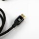 A braided HDMI cable with a gold connector on a white surface