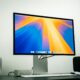 A 27-inch monitor on a desk with a Mac mini, keyboard and speakers