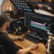 An editor at a desk working a video timeline on a large monitor, controller and keyboard in front