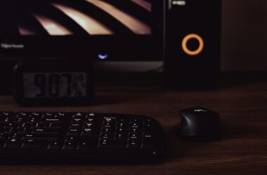 A dark editing desk at night with a mechanical keyboard, a mouse and a monitor