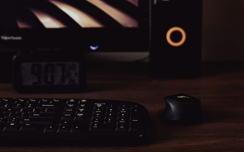 A dark editing desk at night with a mechanical keyboard, a mouse and a monitor